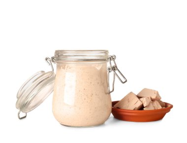 Taze ekşi mayalı kavanoz ve beyaz arka planda maya.