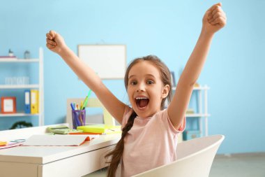 Mutlu küçük kız evde ders yapıyor.