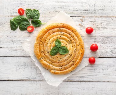 Hafif ahşap zemin üzerinde ıspanaklı turta.