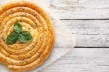 Hafif ahşap zemin üzerinde ıspanaklı turta.