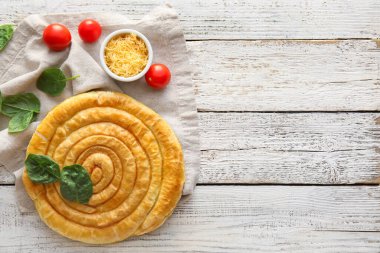 Hafif ahşap zemin üzerinde lezzetli ıspanaklı turta kompozisyonu