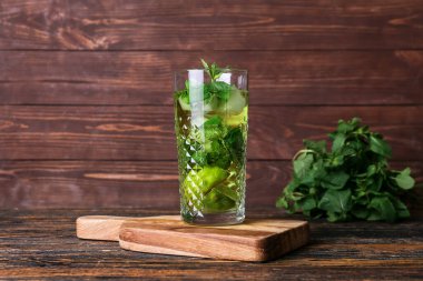 Koyu ahşap arka planda limonlu bir bardak lezzetli nane çayı.