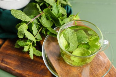 Ahşap tahtalarda bir bardak nefis nane çayı, yakın plan.