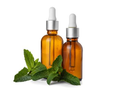 Beyaz zemin üzerinde taze nane olan kozmetik damlası şişeleri.