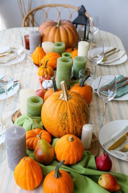 Oda da taze balkabakları ve mumlarla dolu güzel bir masa.