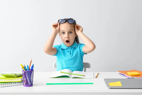 Scioccato Bambina Facendo Compiti Tavola Sfondo Chiaro — Foto Stock