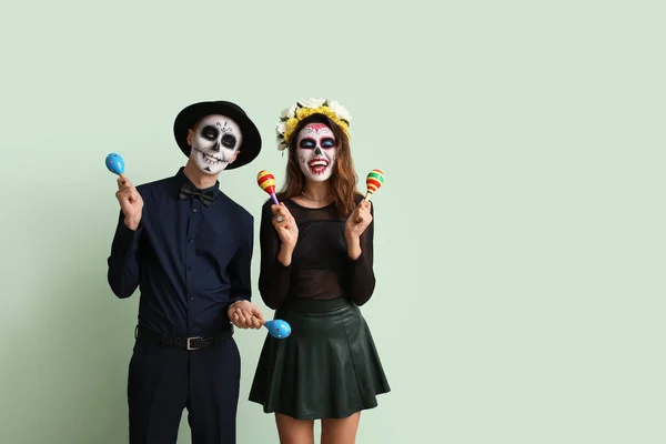 Young Couple Painted Skull Faces Maracas Color Background Celebration Mexico — Stock Photo, Image
