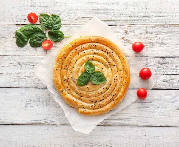 Hafif ahşap zemin üzerinde ıspanaklı turta.