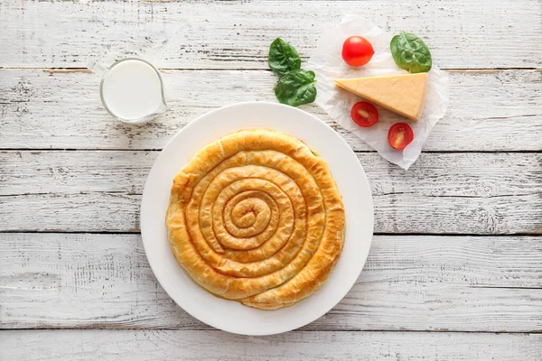 Hafif ahşap zemin üzerinde lezzetli ıspanaklı turta kompozisyonu