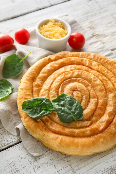 Hafif ahşap zemin üzerinde ıspanaklı turta.