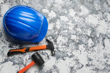 Sert şapka, çekiç ve çekiç arka planda.