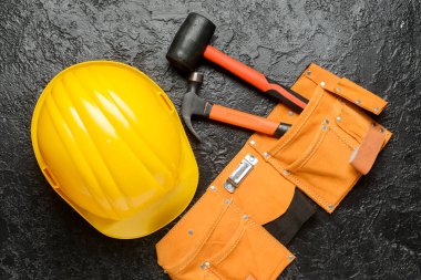 Koyu arkaplanda araçları olan sert şapka ve kemer