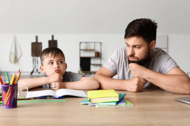 Babasıyla birlikte küçük çocuk evde ders yapmaktan yoruldu.