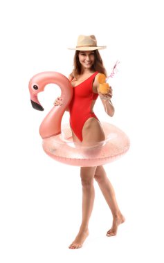 Kokteyl ve beyaz arka planda şişme yüzük olan genç bir kadın.