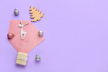 Noel dekorlu zarf ve eflatun arkaplanda mevcut