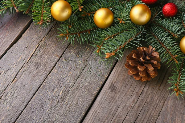 木製の背景にコーンとボールとクリスマスモミの枝 — ストック写真