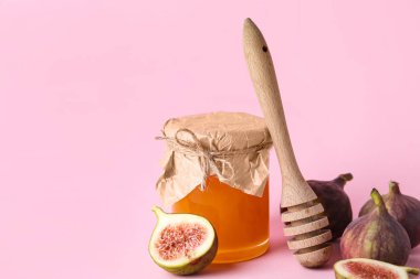 Bal dolu cam kavanoz ve renkli taze incir.