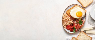 Hafif arka planda sahanda yumurtalı lezzetli İngiliz kahvaltısı.