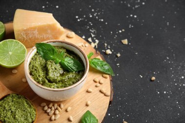 Bir kase lezzetli pesto sosu ve siyah grunge arkaplan içeriği.