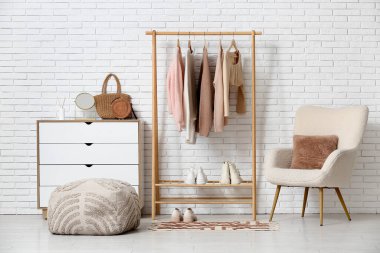 Elbise askısı, koltuğu ve şifoniyeri olan şık bir salon.