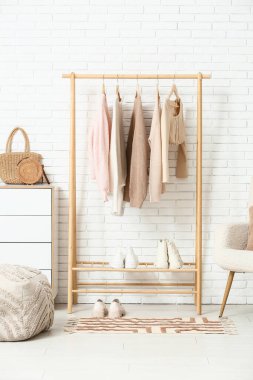 Elbise askısı ve şifoniyeri olan şık bir salonun içinde.