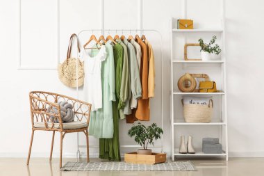 Elbise askılığı, koltuk ve raf ünitesi olan şık bir koridor.