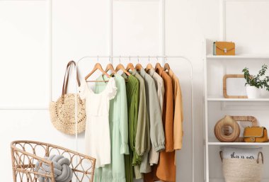 Elbise askılığı, koltuk ve raf ünitesi olan şık bir koridor.