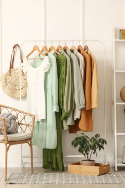 Elbise askılığı, koltuk ve raf ünitesi olan şık bir koridor.