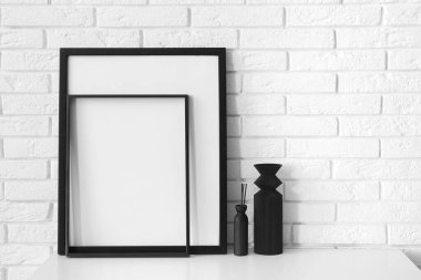 Beyaz tuğla duvarın yanında boş çerçeveli çekmeceler.