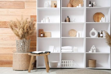 Banyo içinde raf ünitesi, masa ve otlar var.