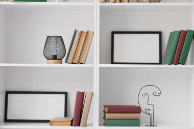Boş çerçeveli kitaplar ve beyaz raflarda dekor