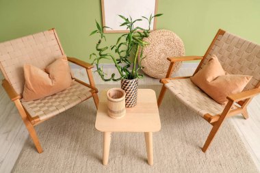 Sehpanın üzerinde koltuklar ve bambu sapları olan şık bir oturma odası.