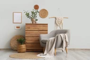 Gri koltuklu ve ahşap şifoniyerli bambu saplı şık oturma odasının içinde.