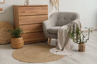 Gri kanepeli, ahşap şifoniyerli ve bambu saplı şık bir oturma odası.