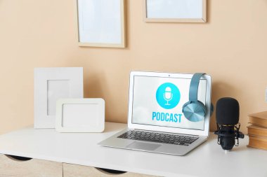 Podcaster 'ın atölyesinde dizüstü bilgisayarı, mikrofonu ve boş çerçeveleri olan iş yeri