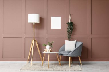 Gri koltuğu, standart lambası ve sehpası olan şık bir oturma odası.