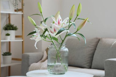 Oturma odasındaki sehpada çiçekli vazo, yakın plan.