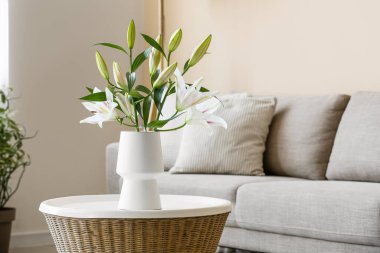 Oturma odasındaki sehpada çiçekli vazo, yakın plan.