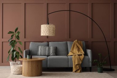 Gri kanepesi, standart lambası ve sehpası olan şık bir oturma odası.