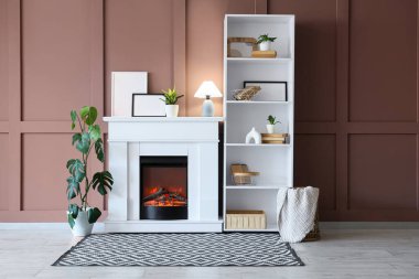 Rafların olduğu rahat bir oda, parlak lamba ve şık bir şömine.