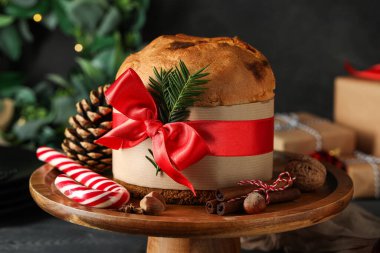 Tatlı Noel Panettone ve şeker bastonuyla dikil siyah ahşap masada, yakın plan