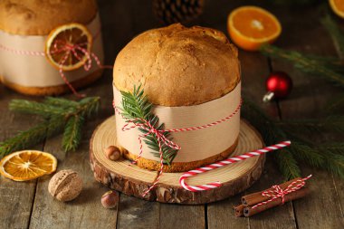 Köknar dalları ve tahta arka planda şeker kamışı olan tatlı Noel Panettone
