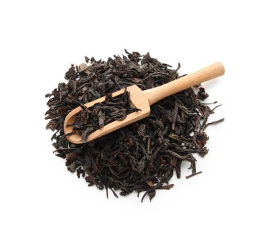 Beyaz arka planda kuru siyah çay yapraklı ahşap kepçe.