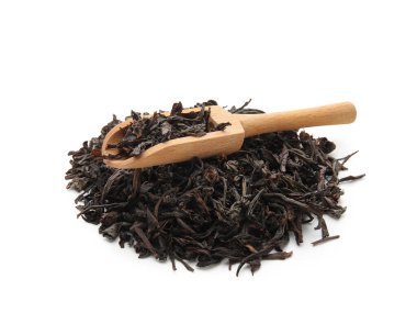 Beyaz arka planda kuru siyah çay yapraklı ahşap kepçe.