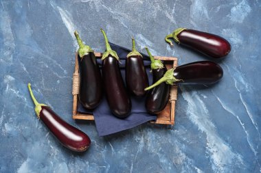 Mavi grunge arka planda taze patlıcanlı ahşap tepsi.