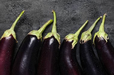 Siyah grunge arka planında ıslak taze patlıcanlar, yakın plan