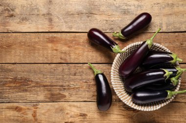 Ahşap zemin üzerinde taze patlıcan olan hasır kase.