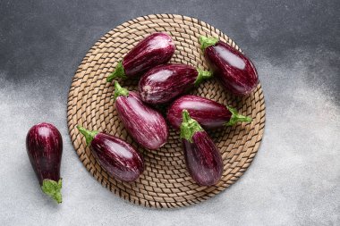 Hasır hasırın üzerinde taze olgun patlıcanlar grunge arka planına karşı