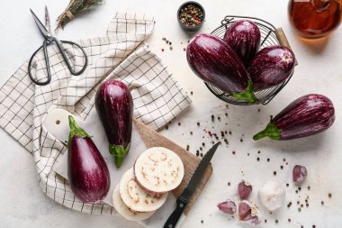 Beyaz arka planda taze olgun patlıcanlarla dolu sepet ve kesme tahtası.