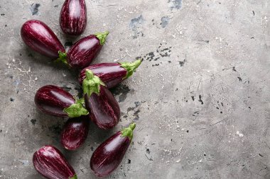 Gri arka planda bir sürü taze patlıcan